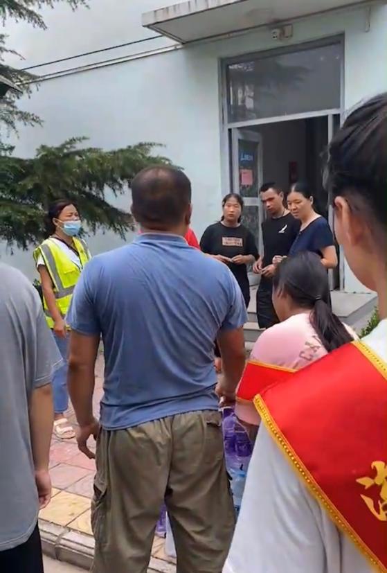 穿白色衣服的男人在街道边的人们低可信度描述已自动生成 穿白色衣服的男人在街道边的人们低可信度描述已自动生成